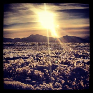 Sun High Over Snowdon reflected in snow crystals on the summit of Pen yr Ole Wen